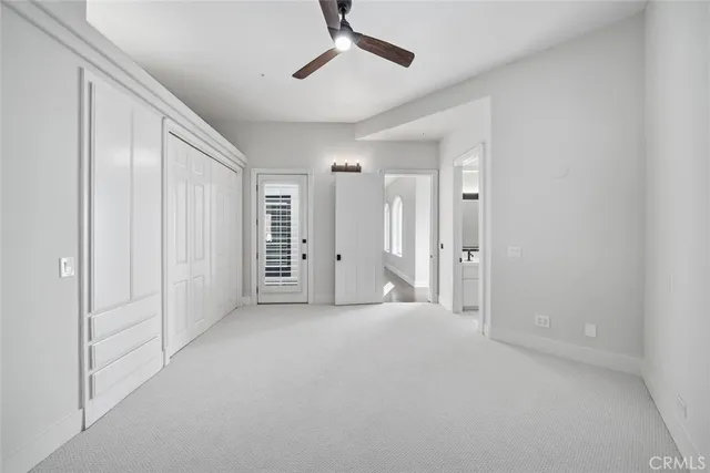 an empty room with a ceiling fan and windows
