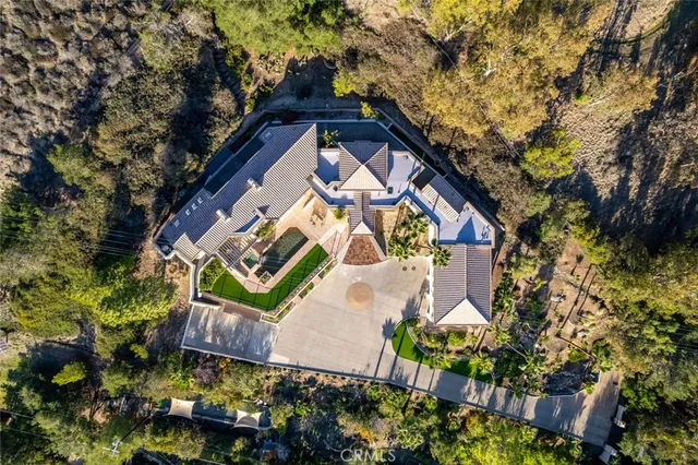 an aerial view of a house with a yard and wooden fence