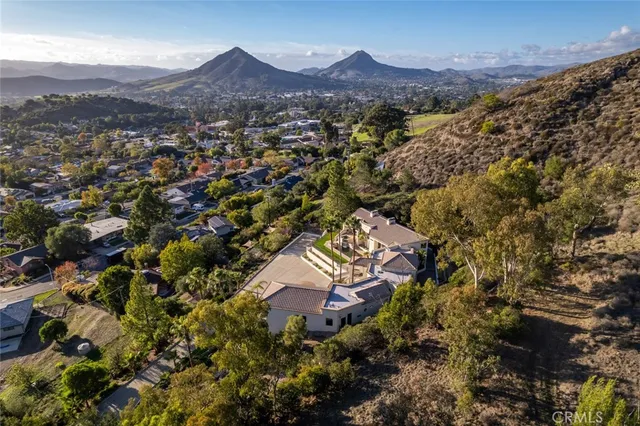 an aerial view of house with yard and mountain view in back