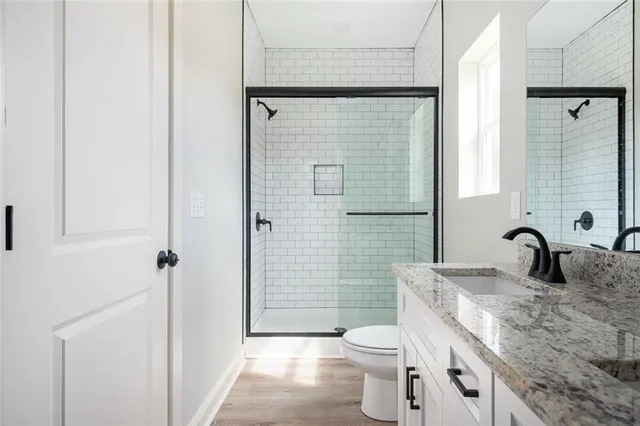 a bathroom with a granite countertop sink toilet and shower