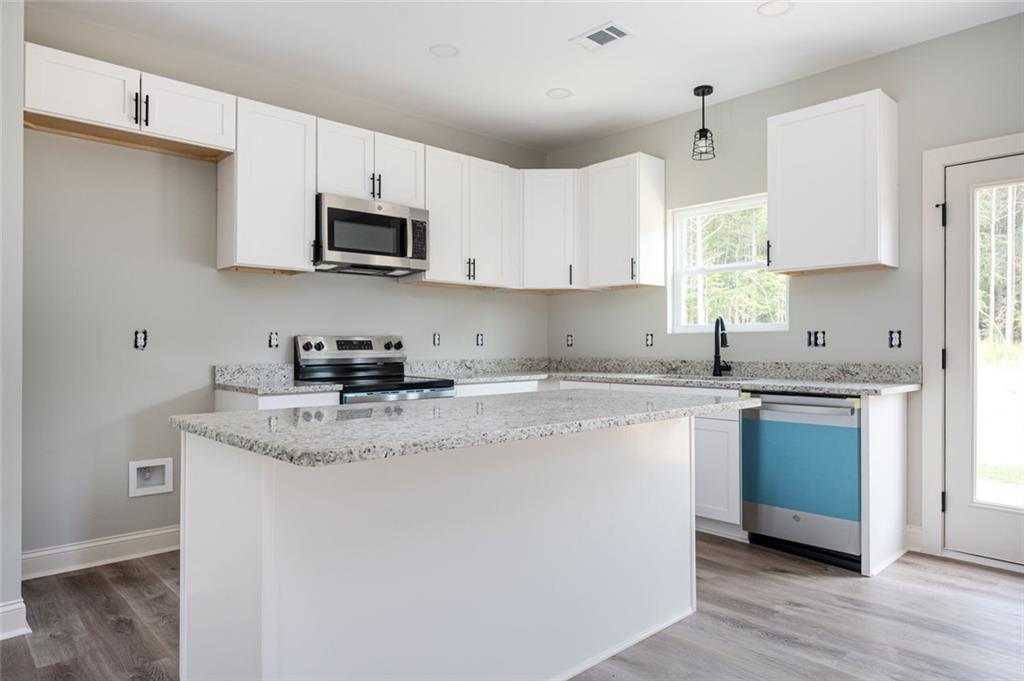 508 Branch Street Cedartown, GA 30125 - Photo 6 of 13 a kitchen with stainless steel appliances granite countertop a sink dishwasher a refrigerator and white cabinets with wooden floor