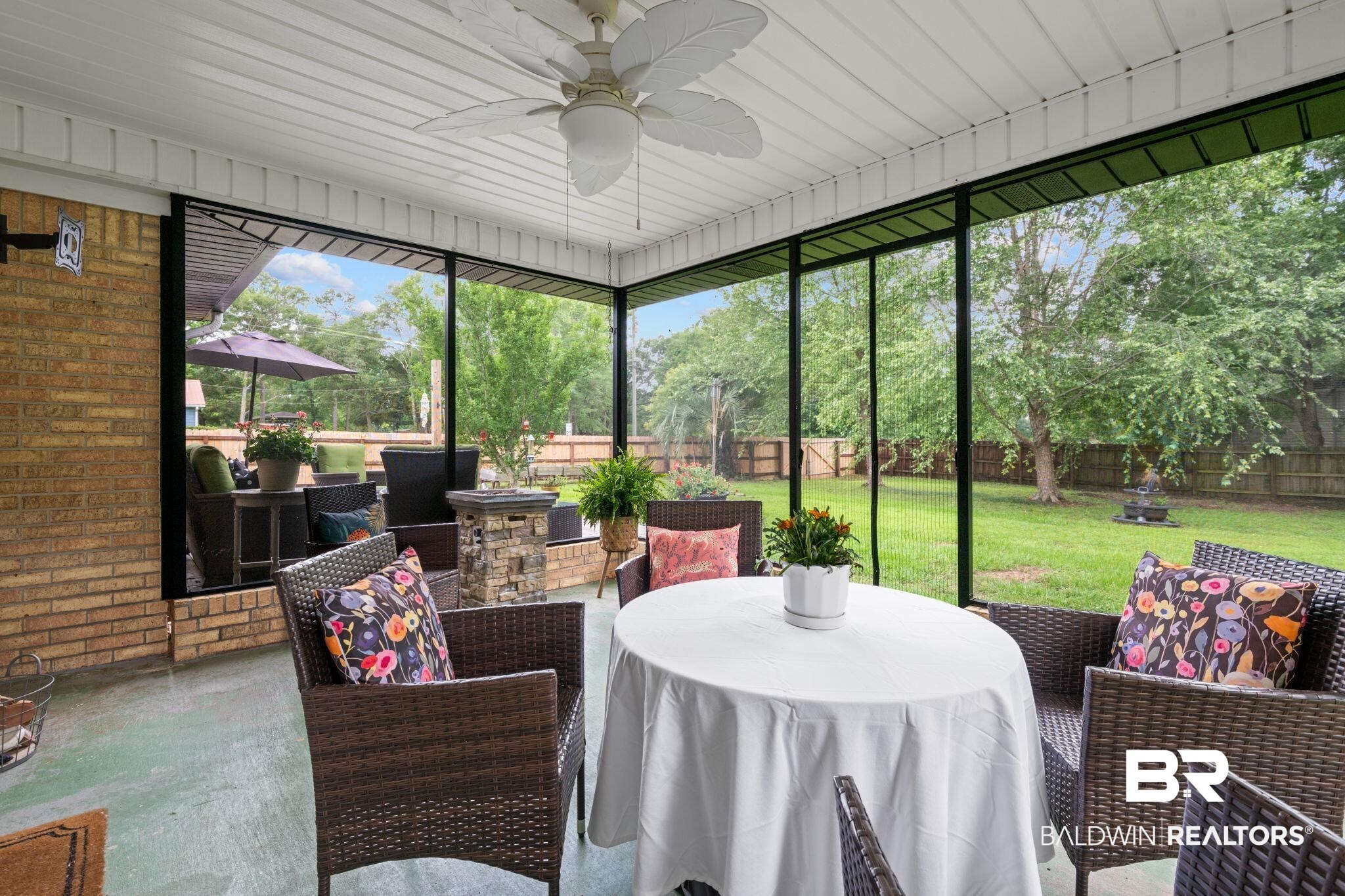 5936 Lundy Road Theodore, AL 36582 - Photo 26 of 32 Screened porch featuring a ceiling fan, brick exterior, and direct access to a spacious grassy yard