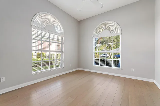an empty room with wooden floor windows and a wooden floor