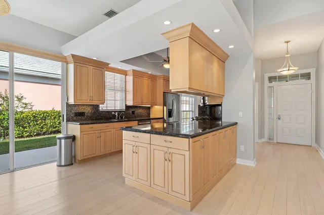 a kitchen with granite countertop a sink stove and refrigerator