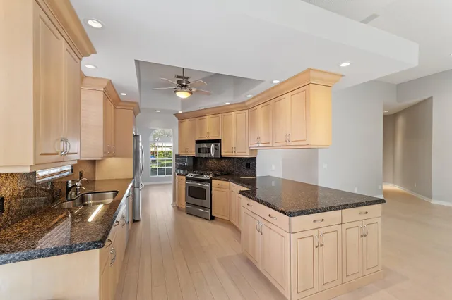 a kitchen with stainless steel appliances granite countertop a sink stove and refrigerator