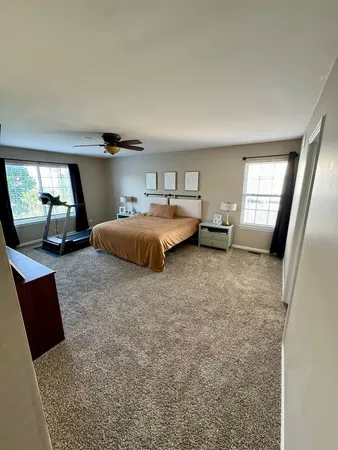 a bedroom with a large bed and a flat tv screen on dresser