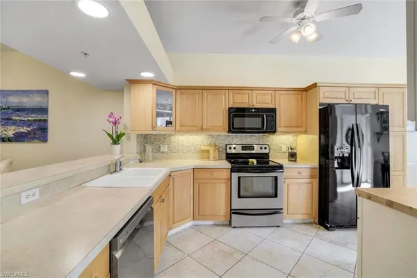 a large kitchen with lots of counter space cabinets and appliances