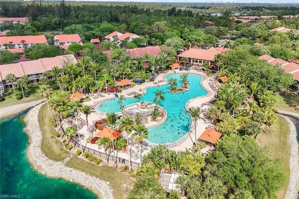 an aerial view of a house with a swimming pool a yard and mountain view in back