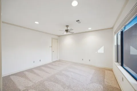 an empty room with a ceiling fan and window