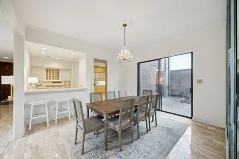 a dining room with furniture a chandelier and wooden floor