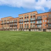 a view of a big building with a big yard and large trees
