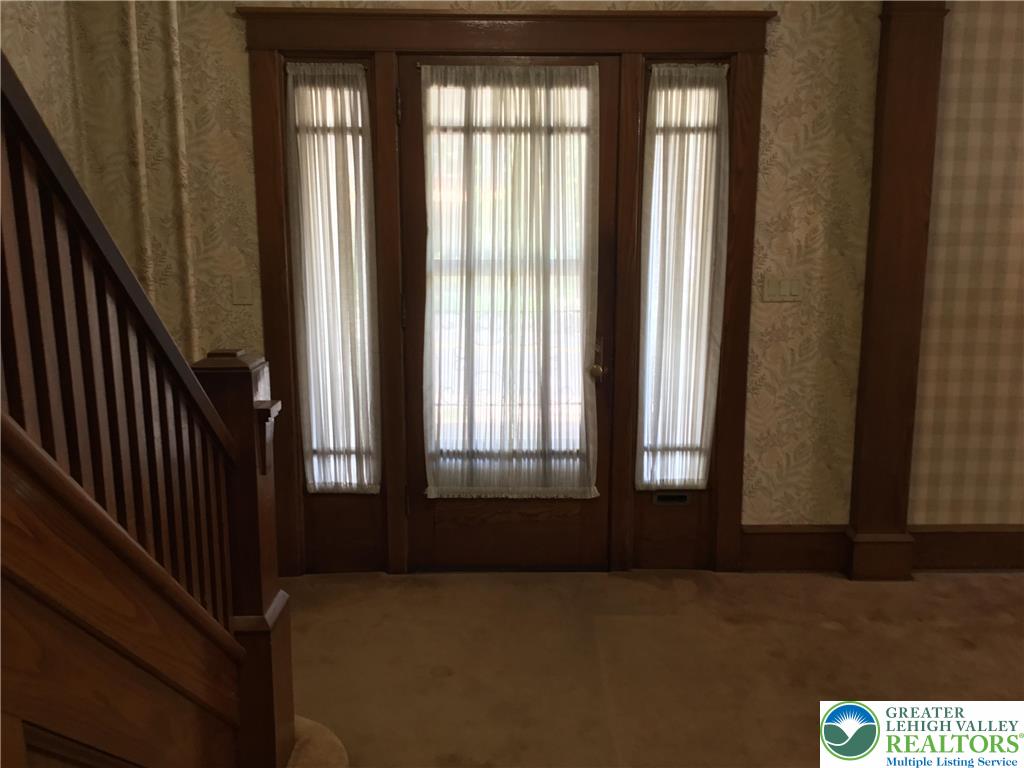 1105 Main Street Slatington, PA 18080 - Photo 3 of 31 A graceful entry with a classic wooden staircase and welcoming door, hinting at heritage charm.