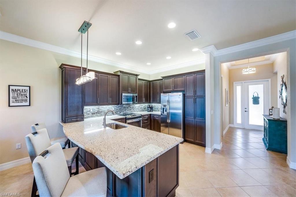 13474 Sumter Lane Naples, FL 34109 - Photo 15 of 25 a kitchen with a table and chairs in it