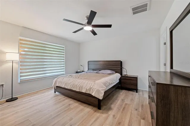 a bedroom with a bed and wooden floor