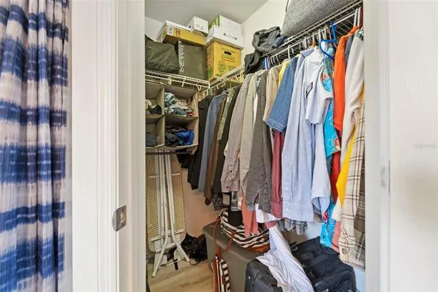 a view of walk in closet with clothes and shoes