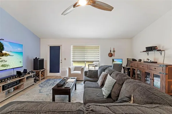 a living room with furniture a flat screen tv and a window