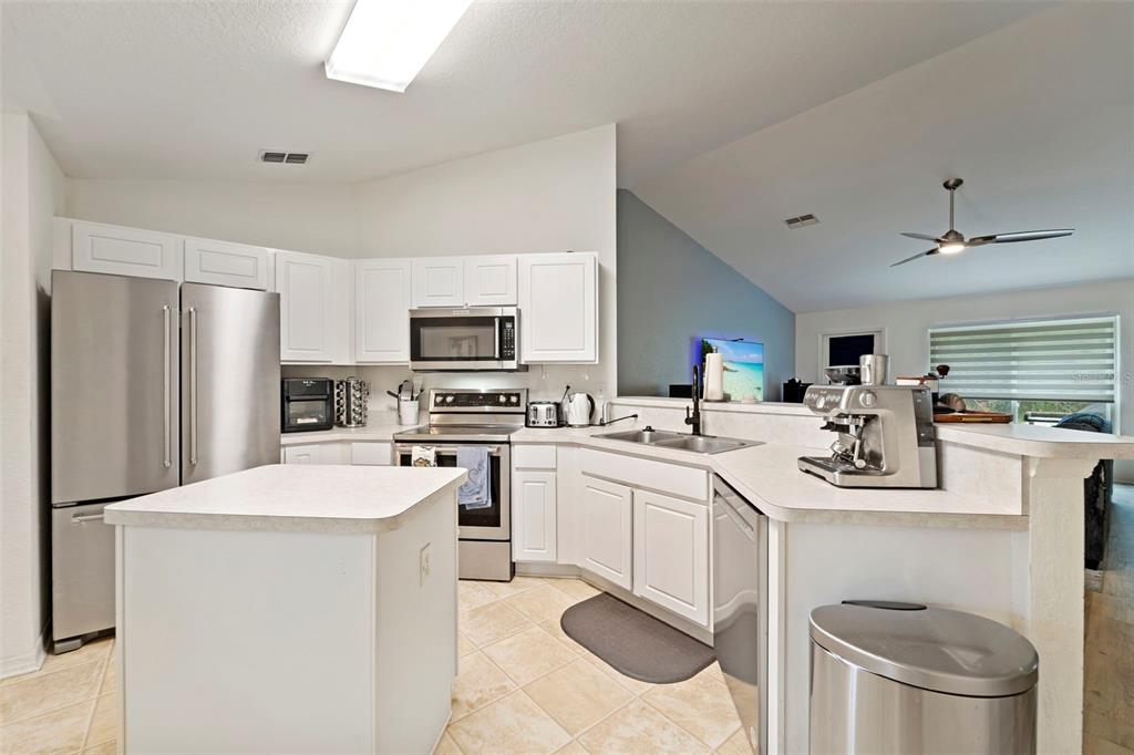 199 Linder Drive Homosassa, FL 34446 - Photo 6 of 29 a kitchen with a sink a stove a refrigerator and white cabinets