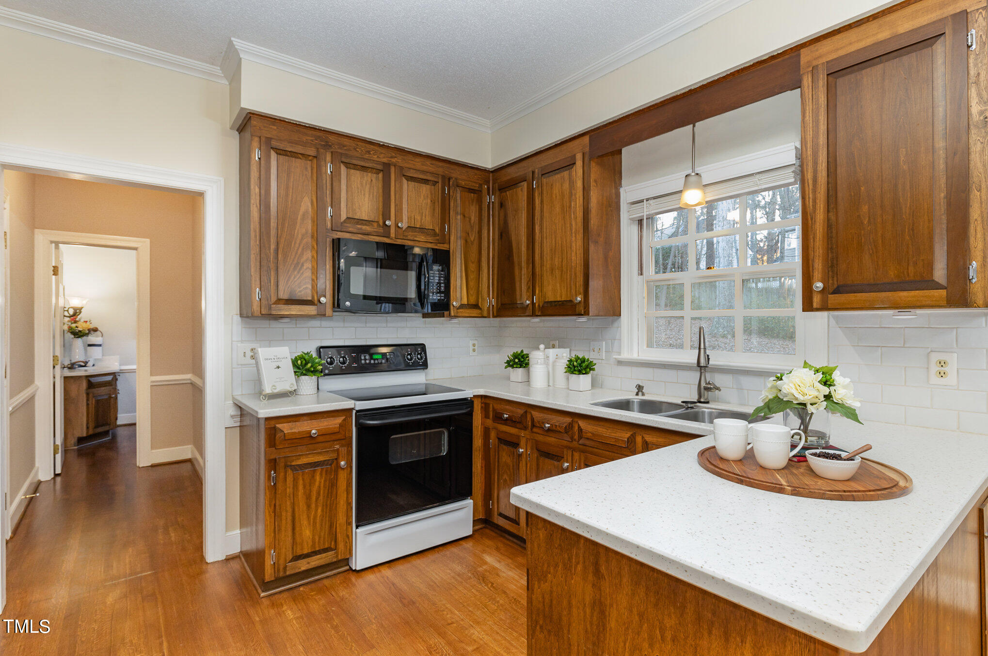 7905 Farnham Court Raleigh, NC 27615 - Photo 8 of 28 a kitchen with stainless steel appliances kitchen island granite countertop a sink dishwasher stove and microwave with wooden floor