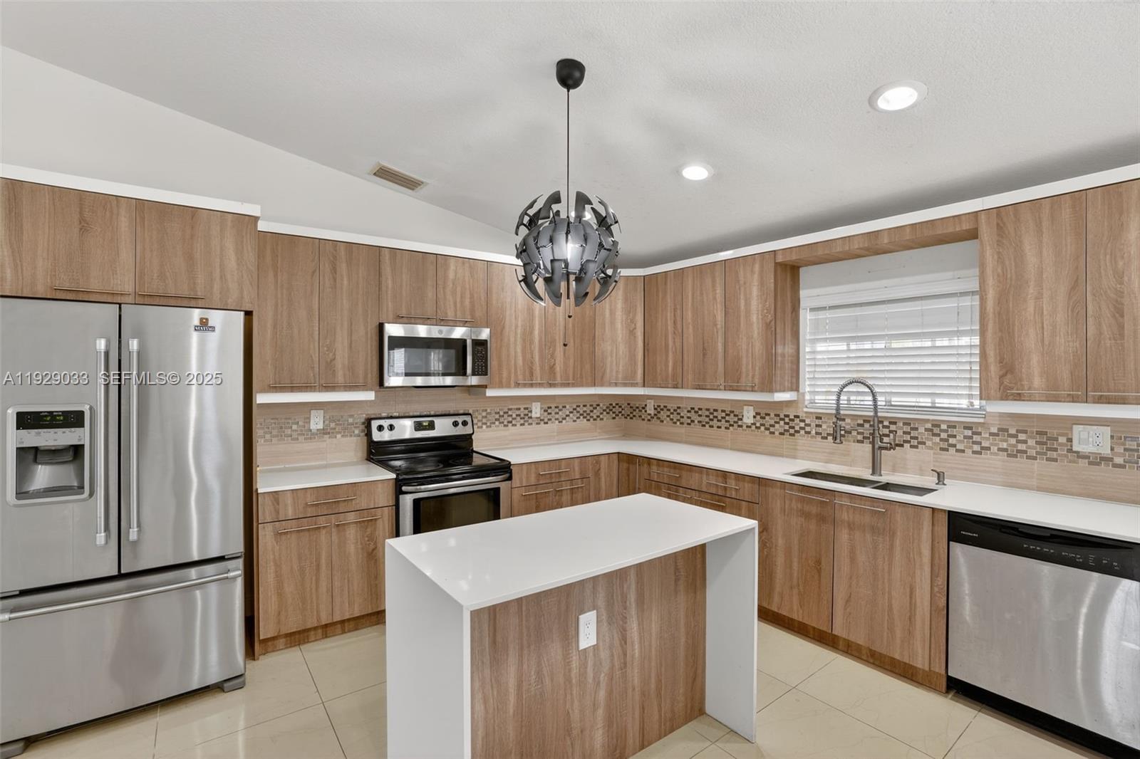 21080 Southwest 242nd Street Homestead, FL 33031 - Photo 11 of 37 a kitchen with kitchen island granite countertop stainless steel appliances a sink stove and refrigerator