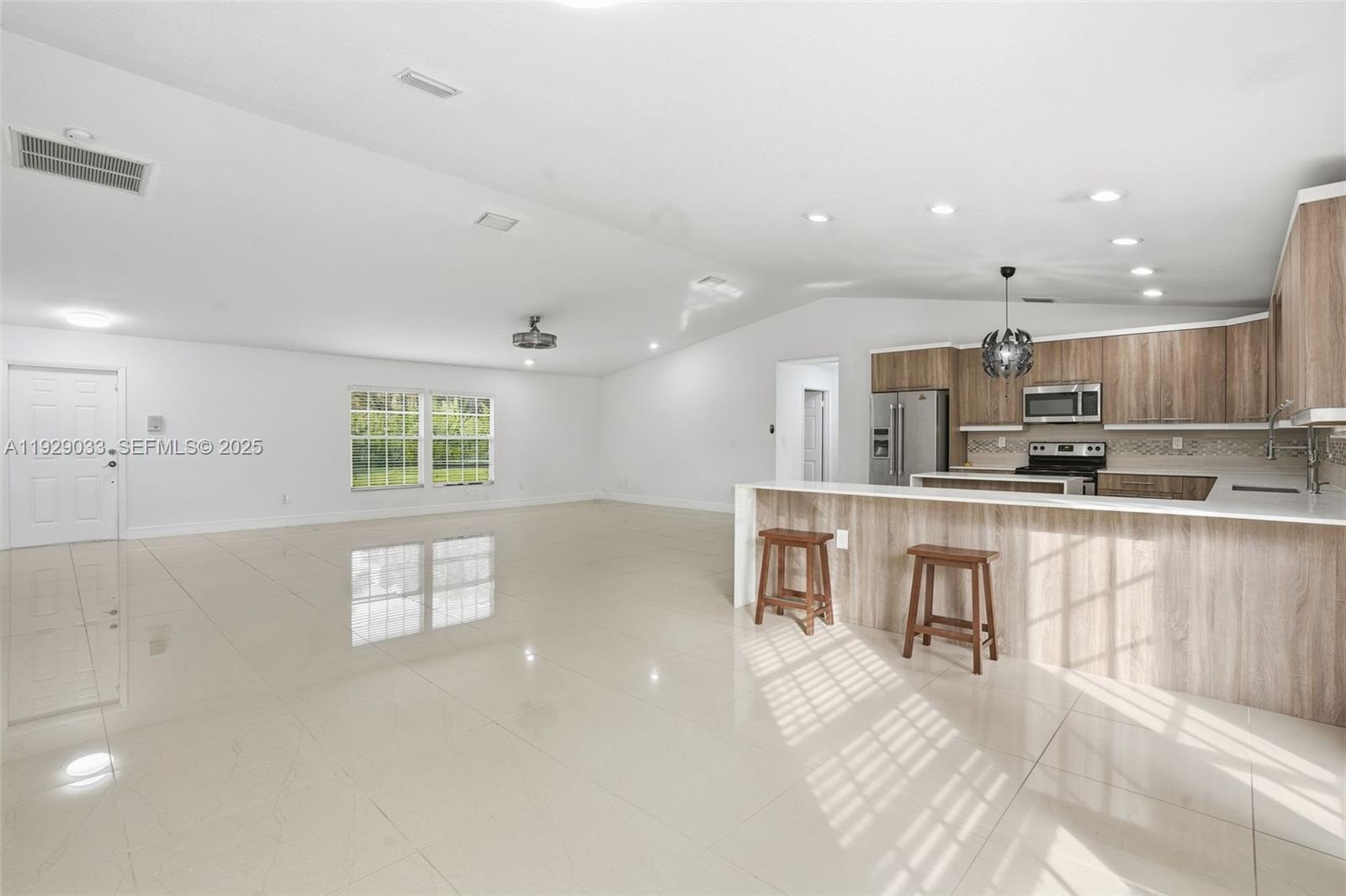 21080 Southwest 242nd Street Homestead, FL 33031 - Photo 10 of 37 a kitchen with kitchen island a sink and a stove top oven