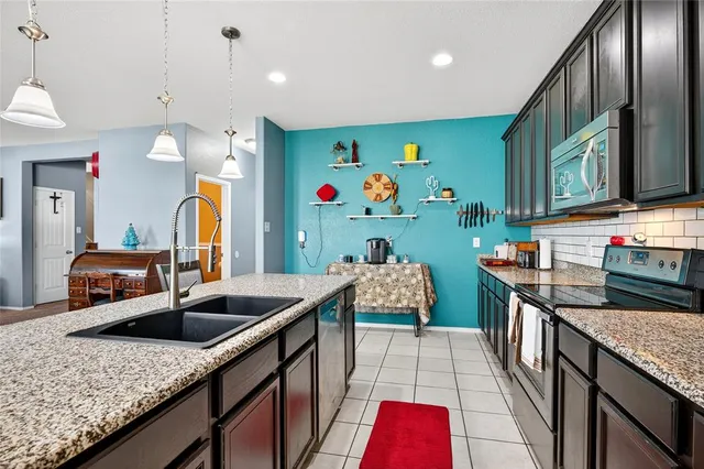 a kitchen with stainless steel appliances granite countertop a sink stove and refrigerator