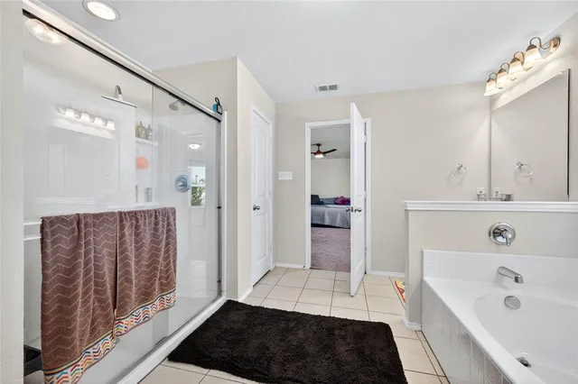 a walk in closet with wooden floor and mirror