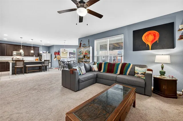 a living room with furniture ceiling fan and a window