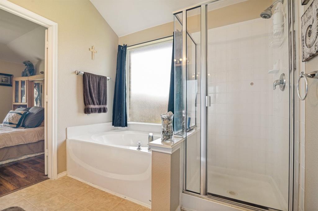 119 Robin Lane Forney, TX 75126 - Photo 16 of 27 Built-in soaking tub with a window, tile flooring, and a glass-enclosed shower with a tiled surround
