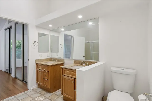 a bathroom with a granite countertop toilet sink and mirror