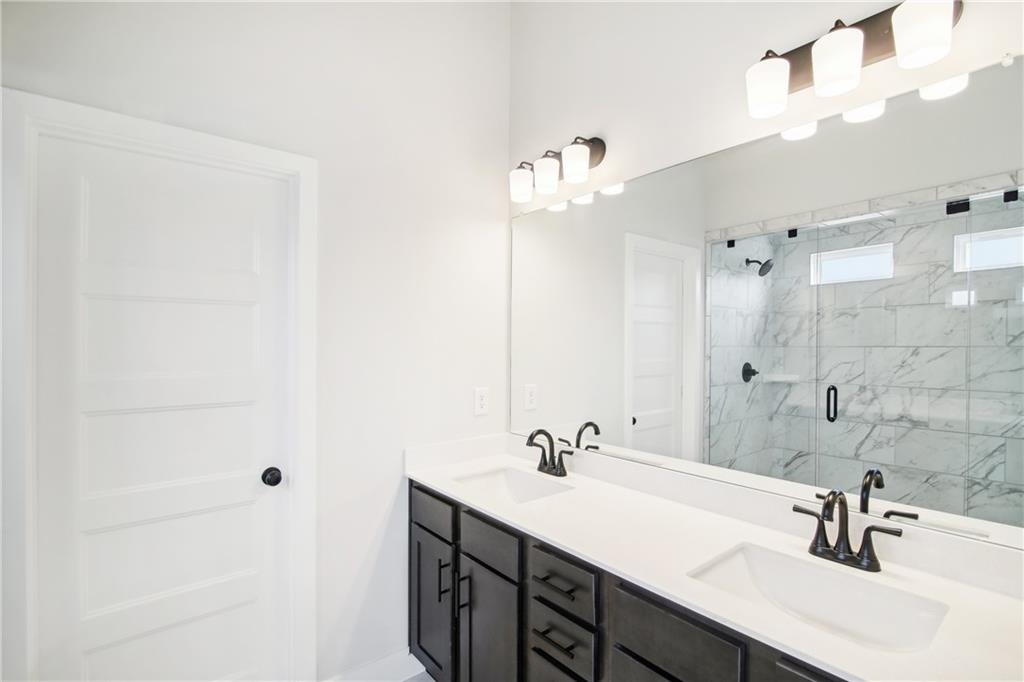 163 Wingate Drive Winder, GA 30680 - Photo 30 of 79 a bathroom with a double vanity sink a mirror and shower