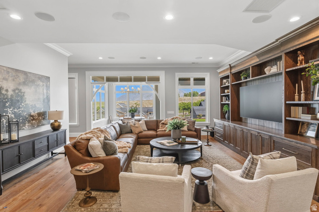 115 East Hidden Ridge Lane, Unit 42 Mapleton, UT 84664 - Photo 57 of 103 Spacious living area featuring extensive built-in cabinetry, large windows, wood-finish flooring, recessed lighting, and crown molding