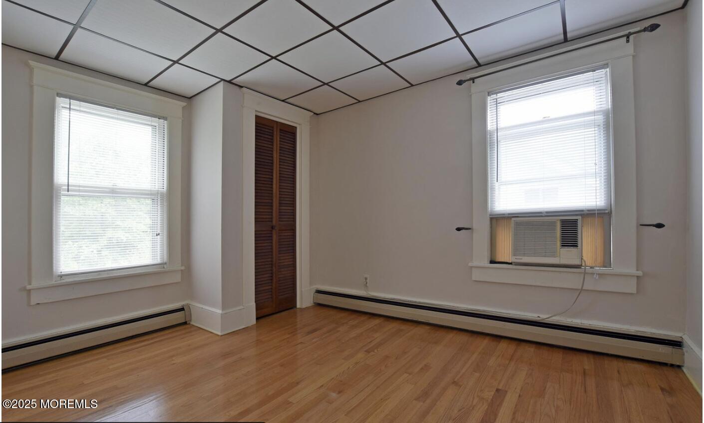 90 Pinckney Road, Unit B Red Bank, NJ 07701 - Photo 8 of 16 an empty room with wooden floor and windows