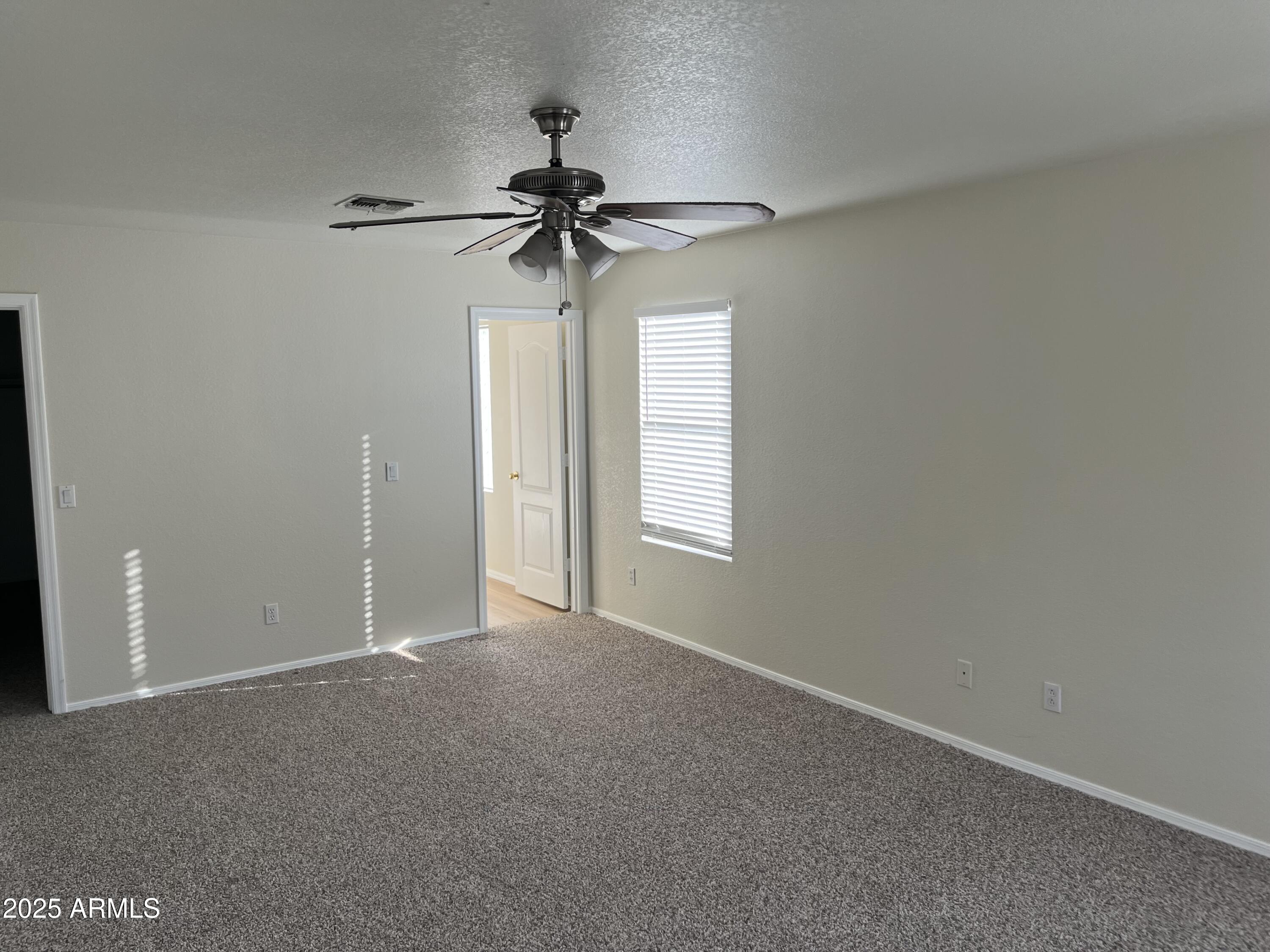 9441 West Jamestown Road Phoenix, AZ 85037 - Photo 7 of 12 an empty room with a window and a fan