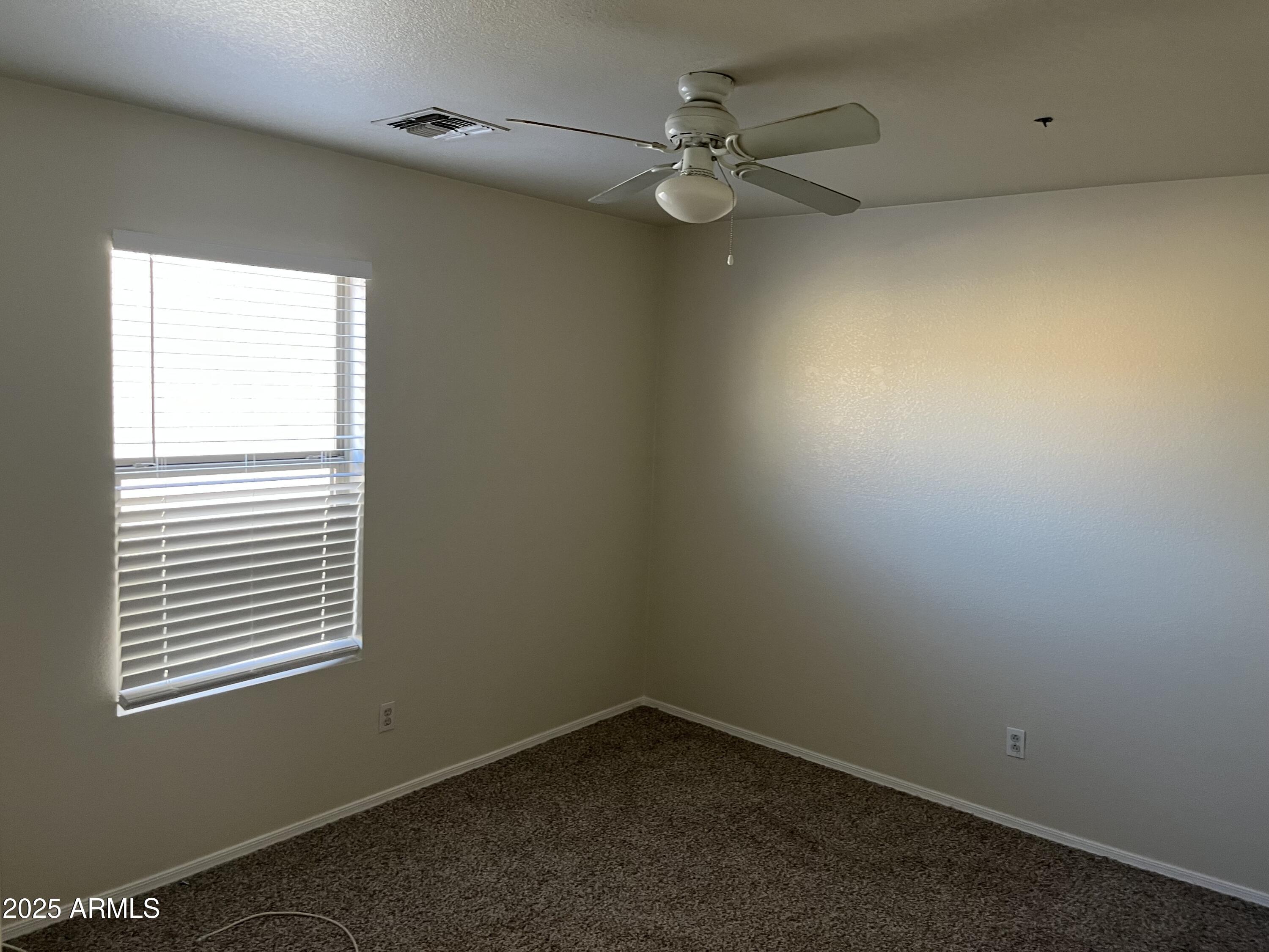 9441 West Jamestown Road Phoenix, AZ 85037 - Photo 10 of 12 an empty room with a window and a fan