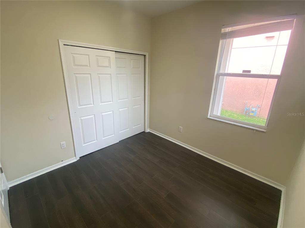 2409 Spring Hollow Loop Wesley Chapel, FL 33544 - Photo 17 of 47 an empty room with wooden floor and windows