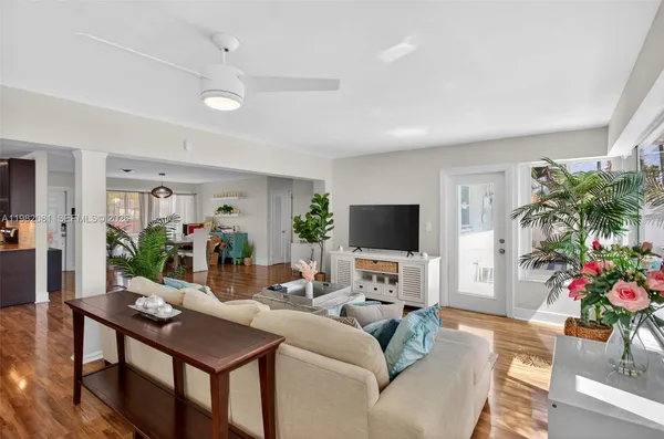 a living room with furniture a flat screen tv and a potted plant