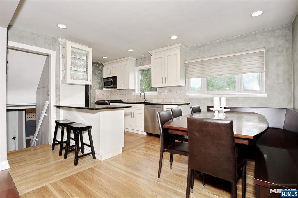 87 Barbara Road Dumont, NJ 07628 - Photo 14 of 48 a kitchen with granite countertop a dining table chairs and a refrigerator