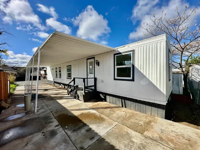 a view of a house with backyard and sitting area