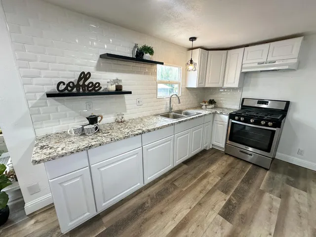 a kitchen with stainless steel appliances granite countertop a sink and stove