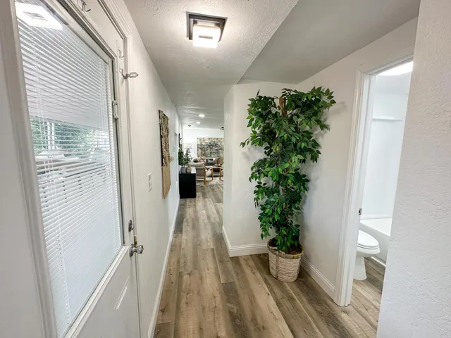 a view of a hallway with wooden floor and a potted plant