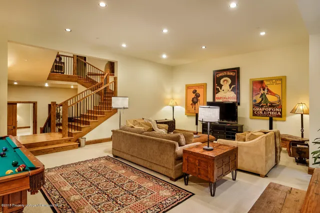 a living room with fireplace furniture and a rug