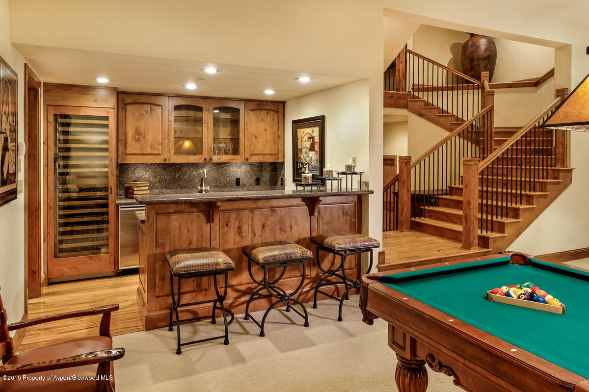 64 Prospector Road, Unit 7 Aspen, CO 81611 - Photo 12 of 23 a kitchen with stainless steel appliances kitchen island granite countertop a table and chairs in it