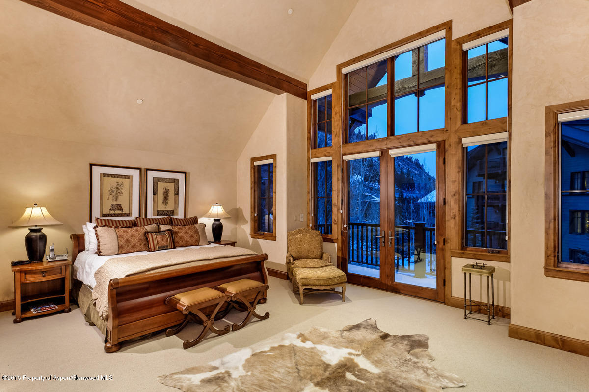 64 Prospector Road, Unit 7 Aspen, CO 81611 - Photo 16 of 23 a bedroom with a bed a large window and a book shelf