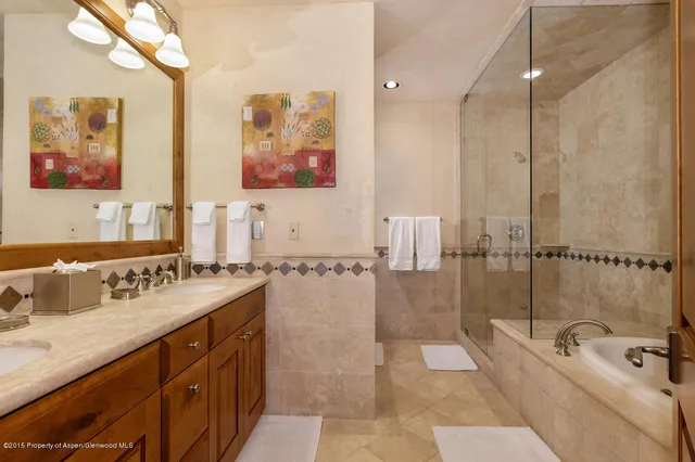 a spacious bathroom with a tub sink and mirror