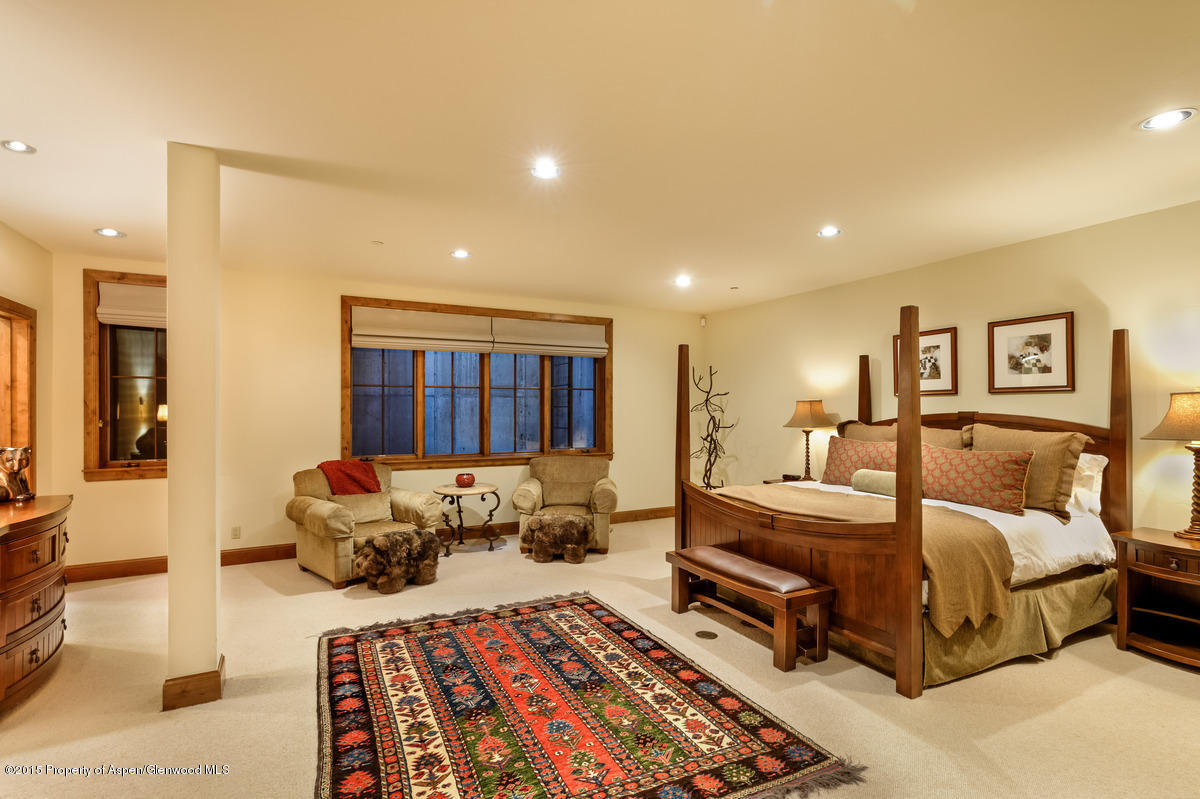 64 Prospector Road, Unit 7 Aspen, CO 81611 - Photo 20 of 23 a spacious bedroom with a large bed and a couch
