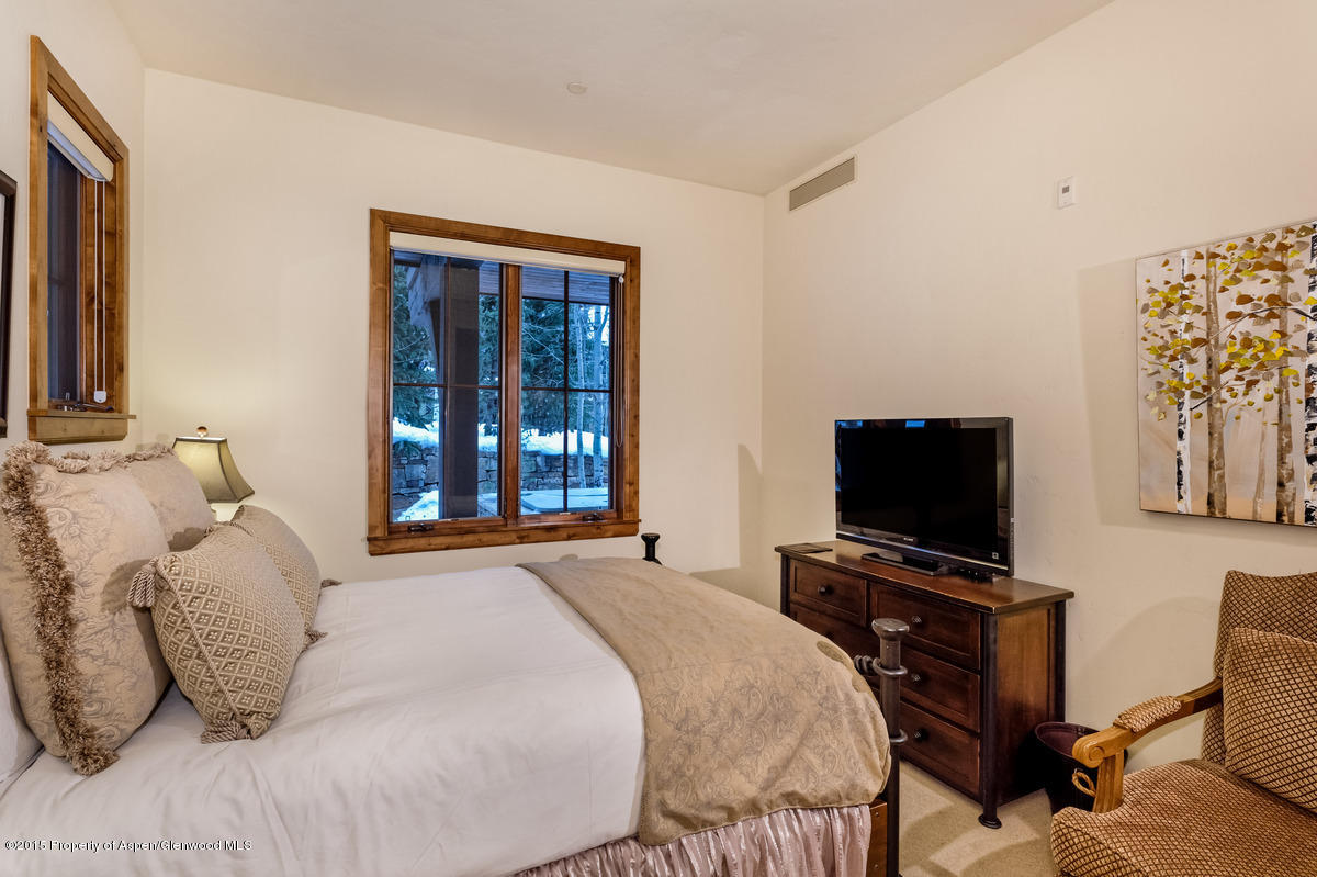 64 Prospector Road, Unit 7 Aspen, CO 81611 - Photo 22 of 23 a bedroom with a bed and a flat screen tv