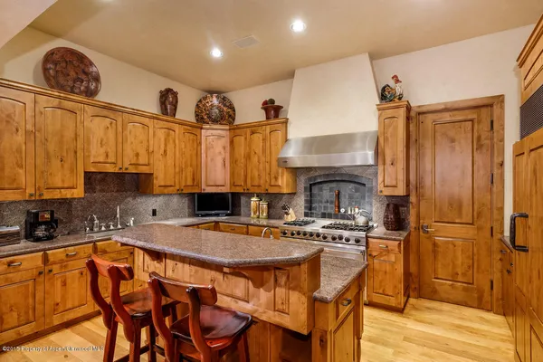 a kitchen with stainless steel appliances granite countertop a sink a stove and a refrigerator