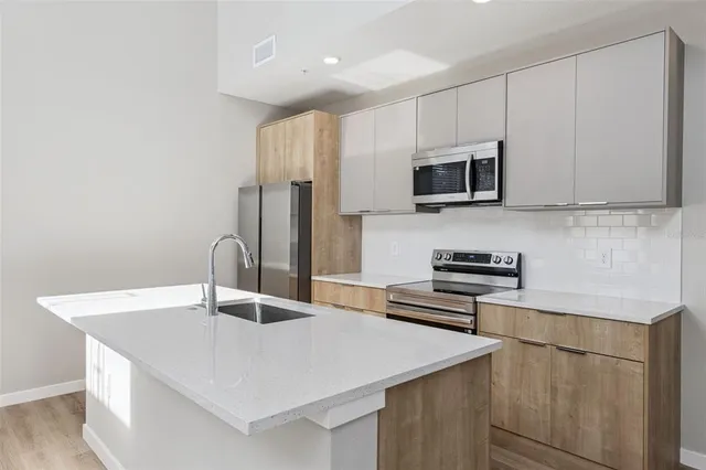 a kitchen with kitchen island a sink stainless steel appliances and white cabinets