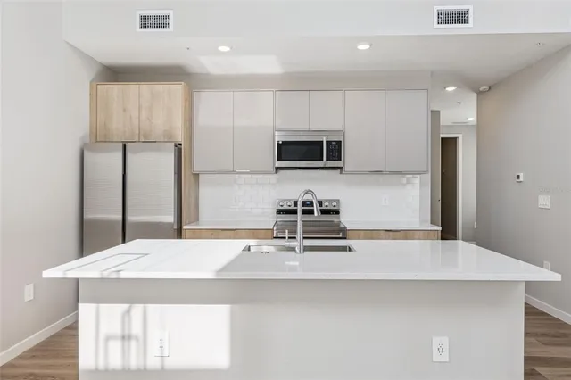 a view of kitchen with wooden floor and electronic appliances