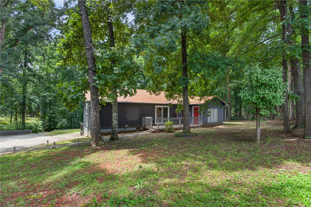 230 Dickard Road Seneca, SC 29672 - Photo 2 of 25 A secluded woodland retreat with a rustic exterior and an inviting porch for quiet evenings.